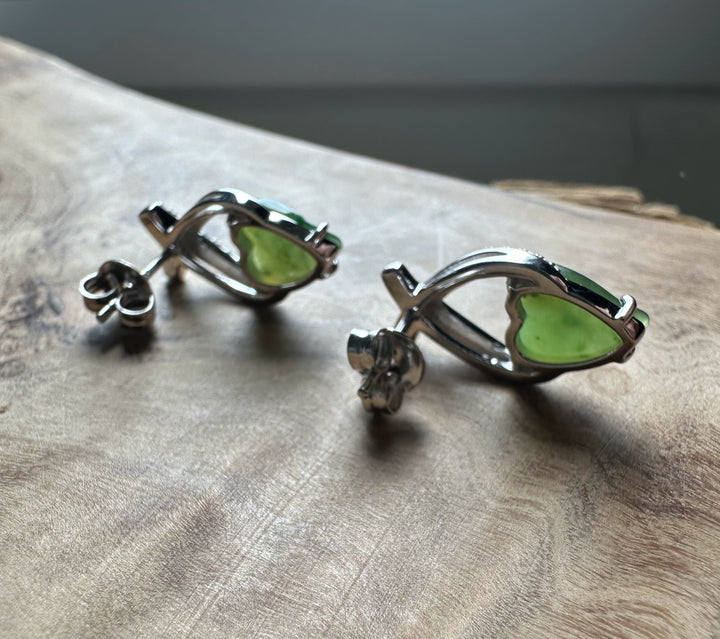jade and silver earrings on wood base