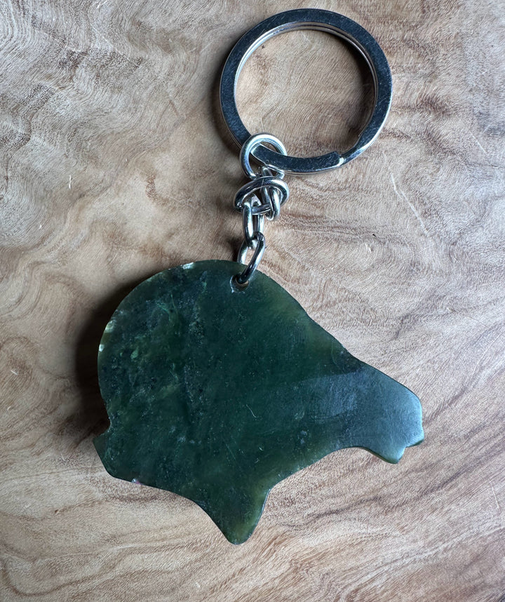 Green stone keychain on a wooden surface