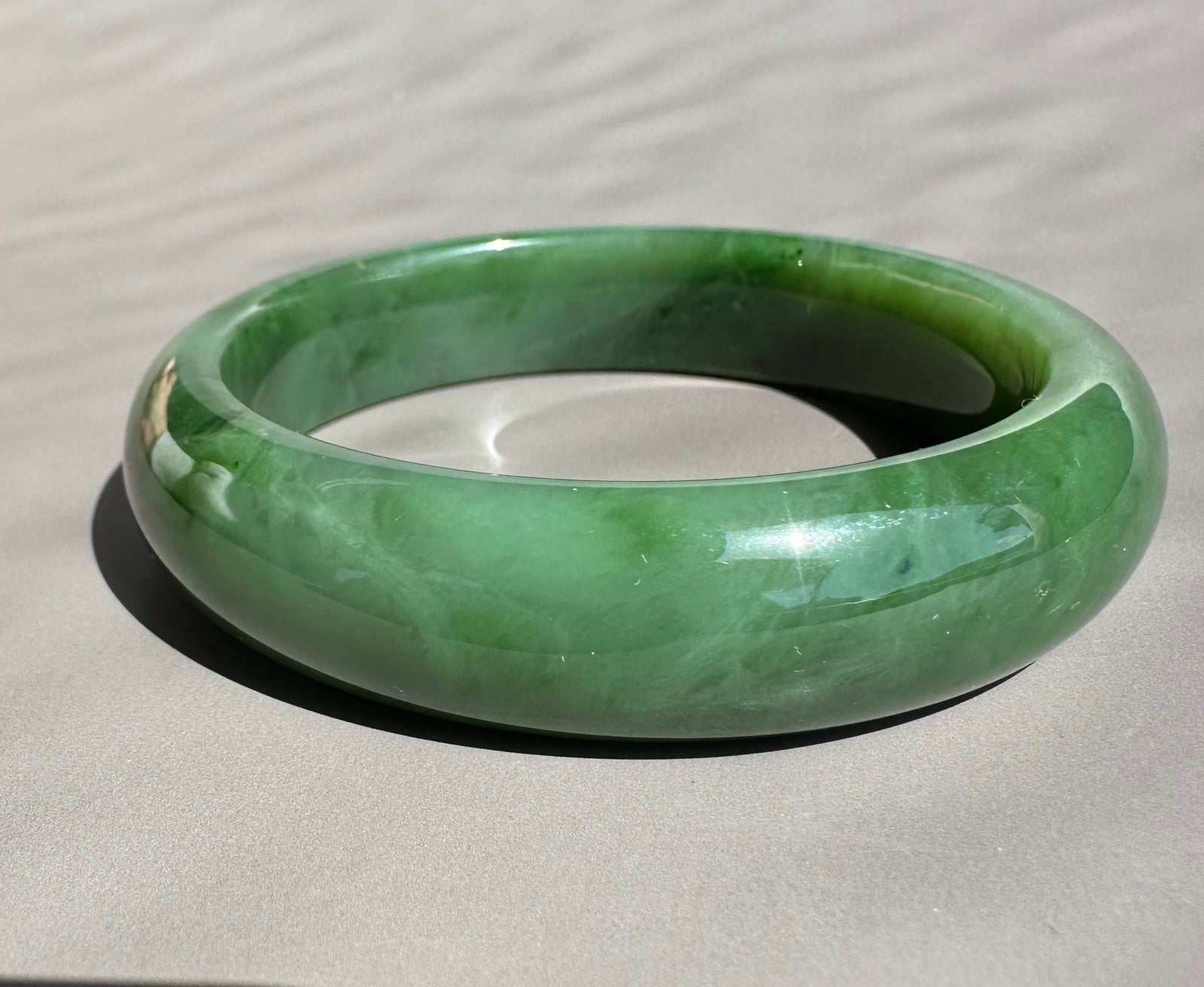 Canadian Jade Bangle 58 x 15mm pale green close up showing a smooth glossy surface