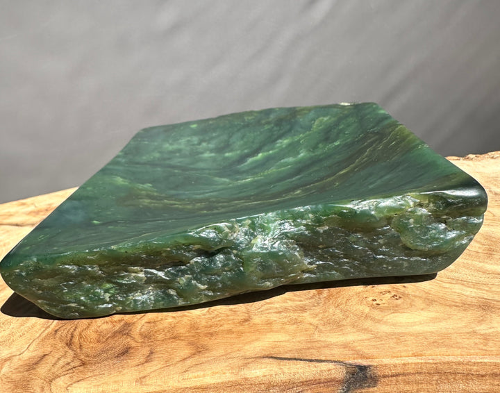 Green jade on a wooden surface with a gray background