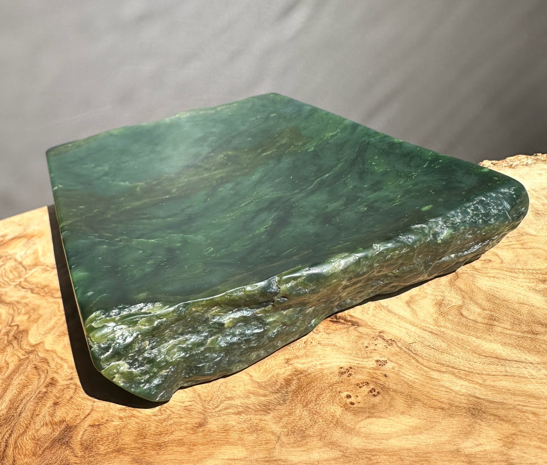 Green jade on a wooden surface with a gray background
