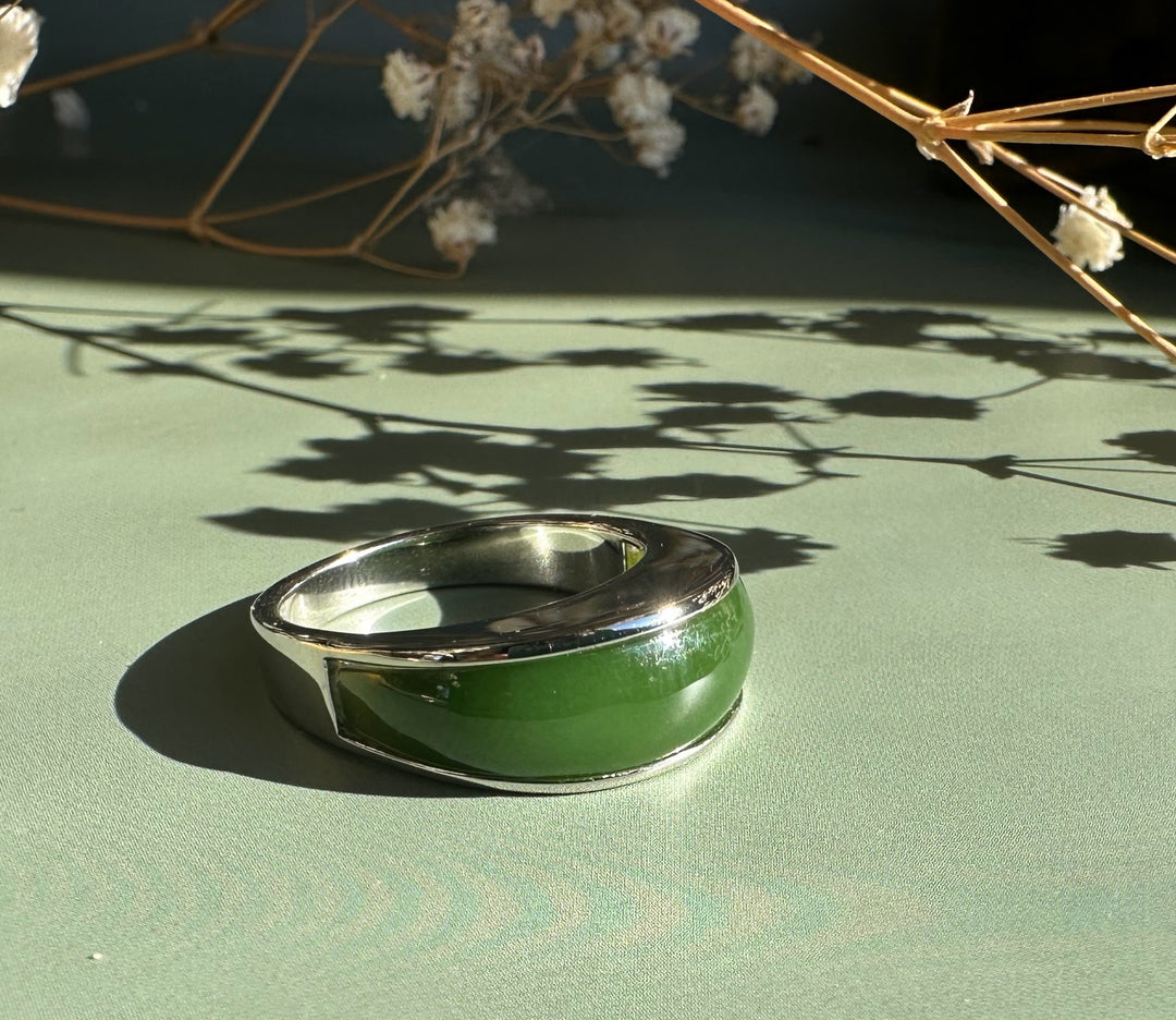 Canadian Jade Ring 3399 close up showing green jade inlay set in a silver band on a green surface
