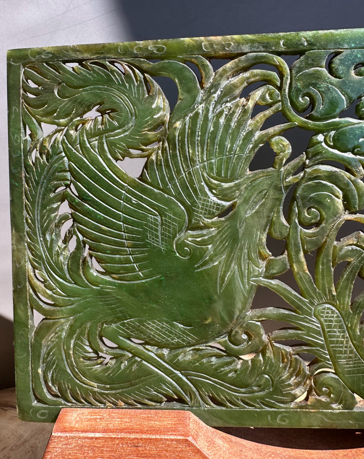 Green jade carving of a phoenix on a wooden stand