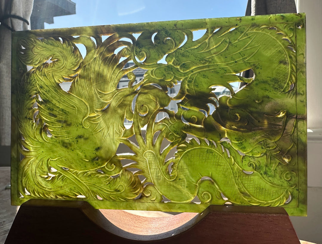Decorative panel with intricate green dragon design on a stand.