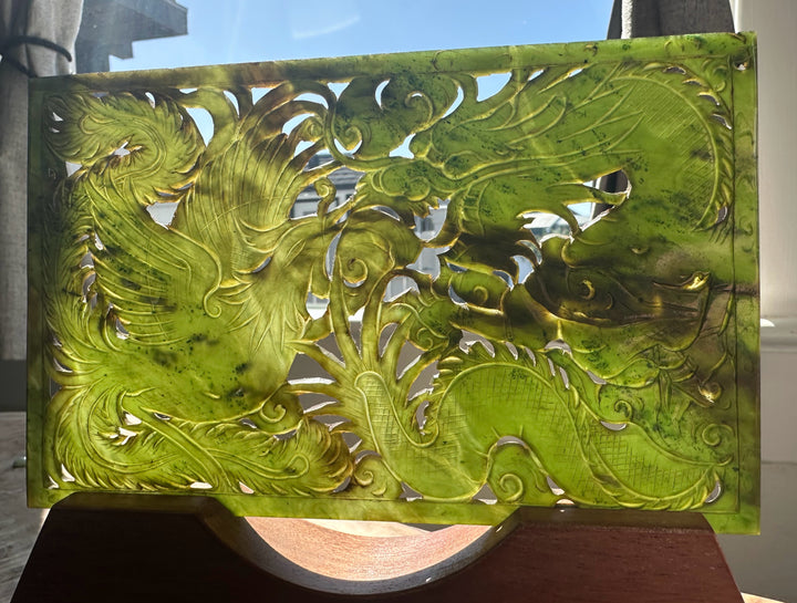 Decorative panel with intricate green dragon design on a stand.