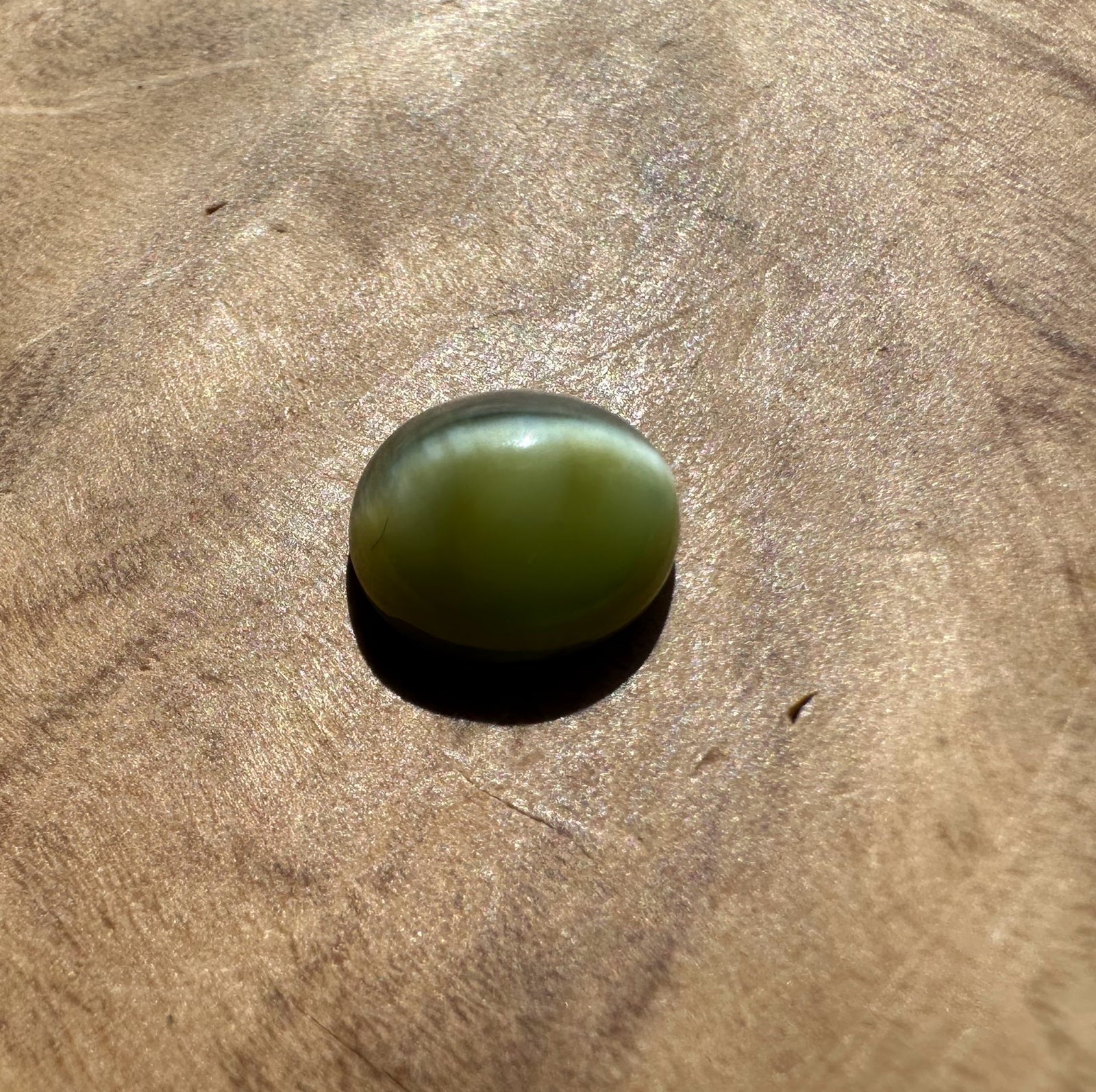 Green stone on a WOODEN surface