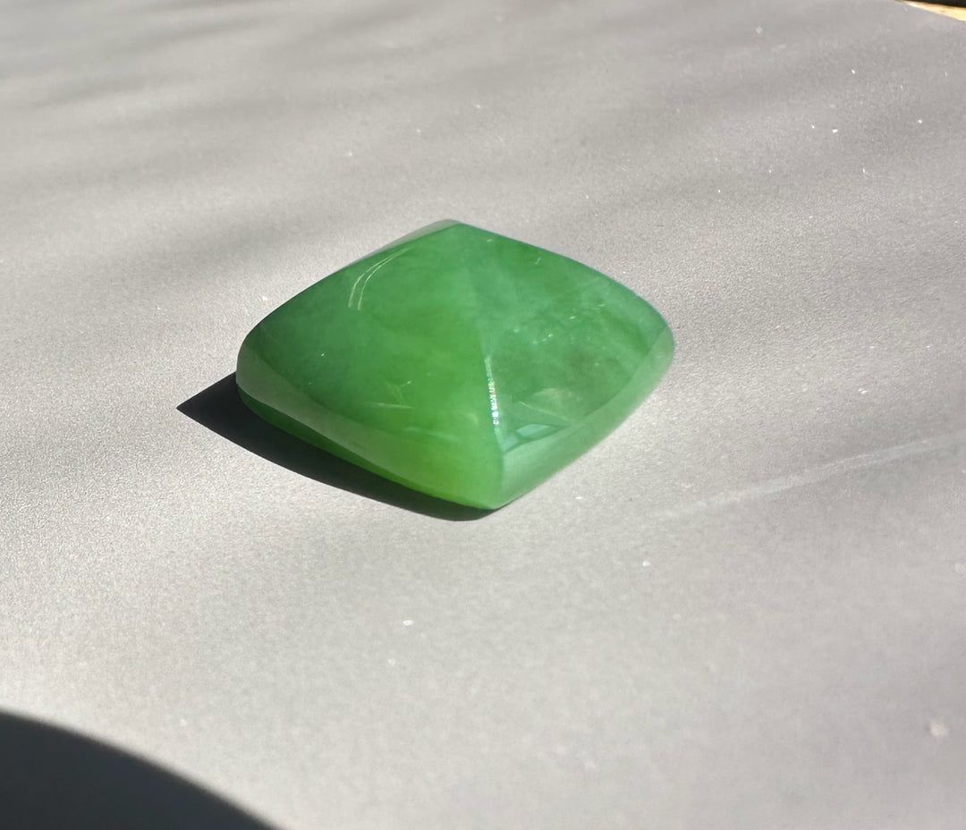Green gemstone on a gray surface