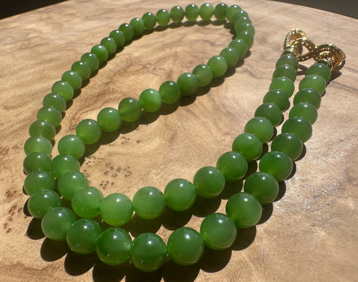 Green beaded necklace on a wooden surface