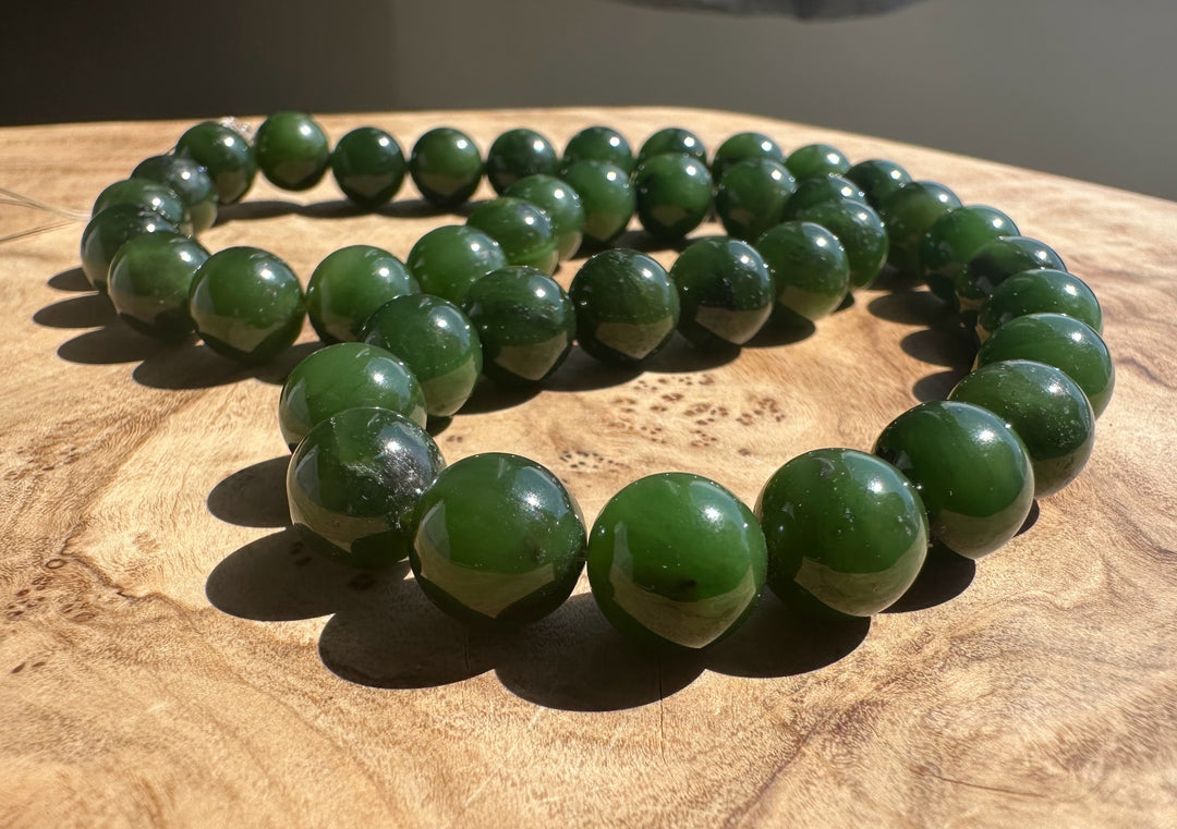 Green jade beads on a wooden surface