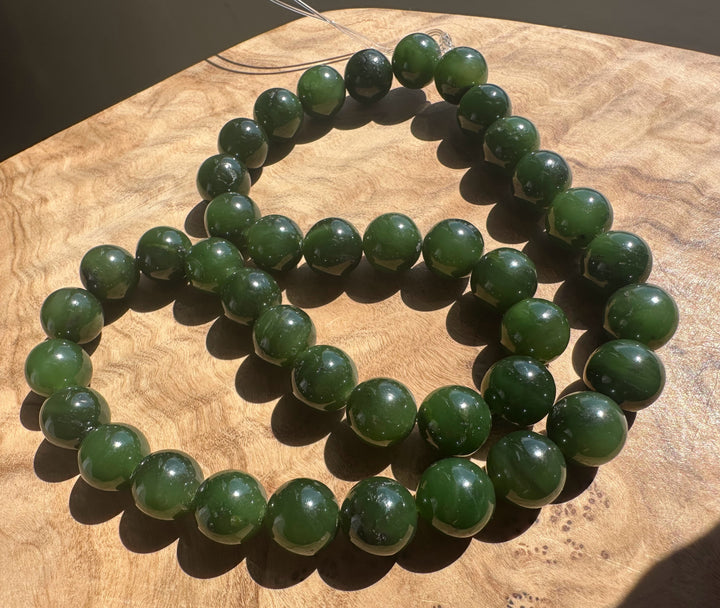 Green jade beads on a wooden surface