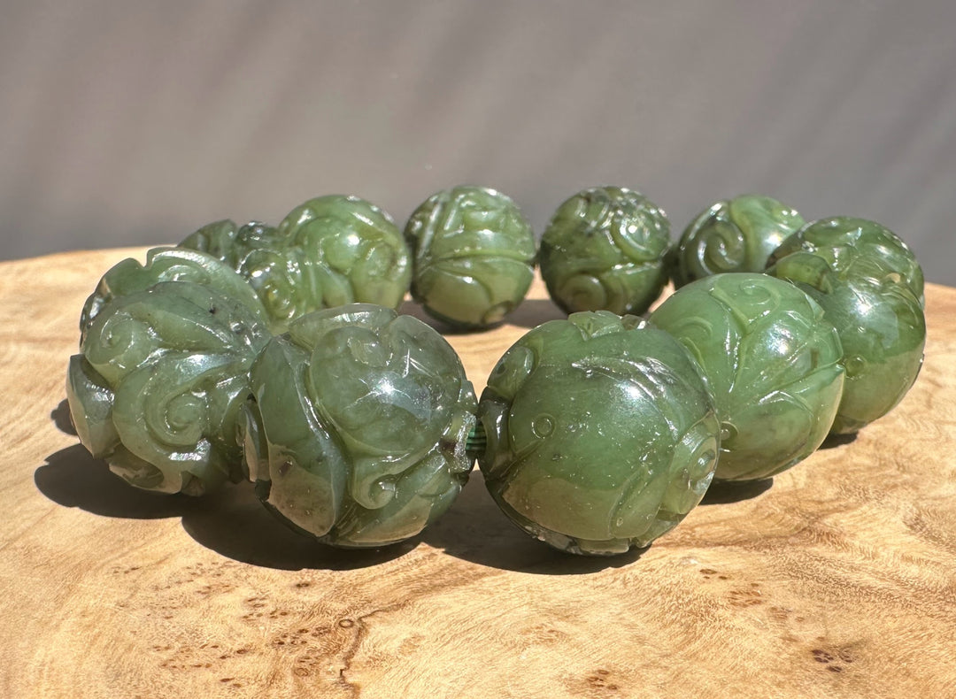 Green jade beads on a wooden surface