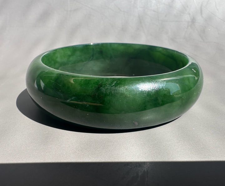 Green jade bangle on a gray background