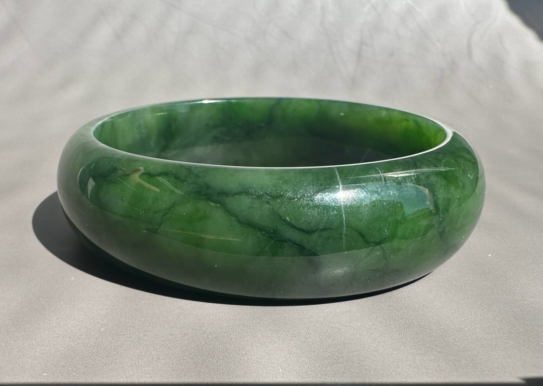 Green jade bracelet on a light gray background
