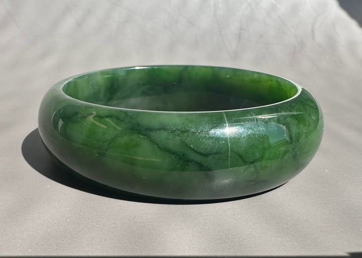 Green jade bracelet on a light gray background