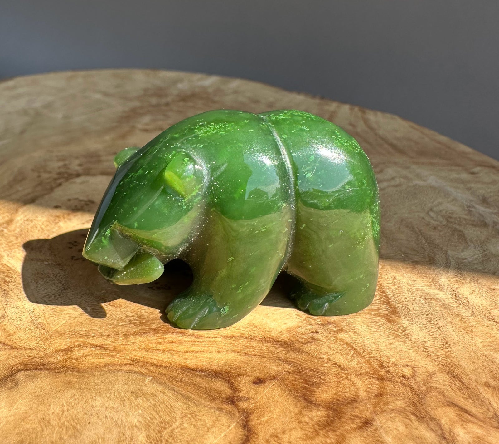 Green jade bear figurine with a small carved fish accent.