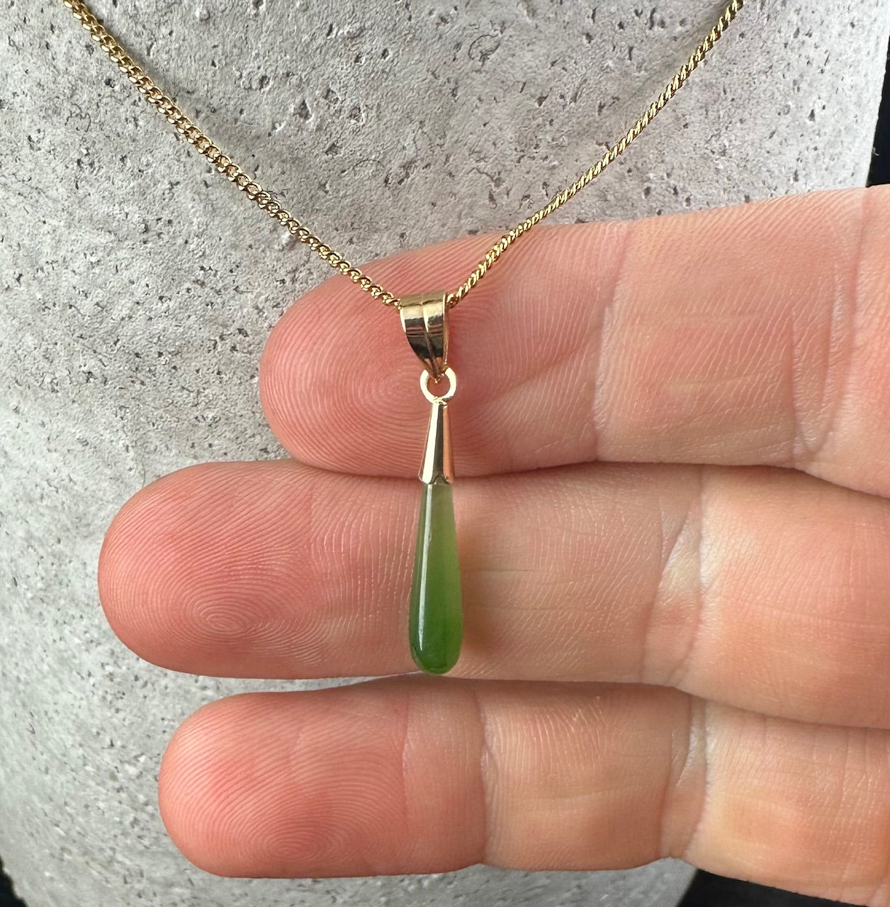 Vintage gold teardrop pendant with a green gemstone drop on a matching gold chain