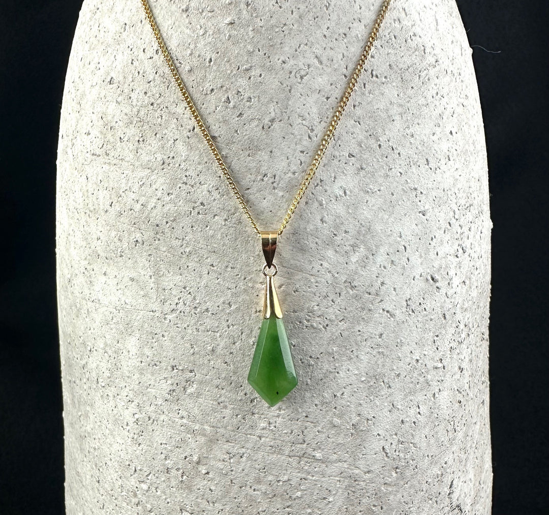 Gold chain necklace with a green gemstone drop pendant