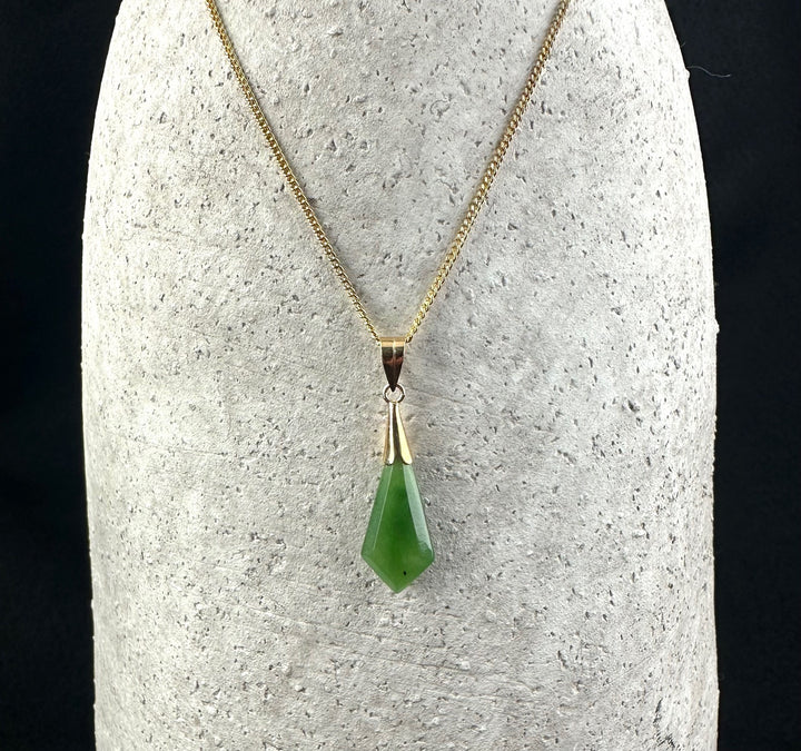 Gold chain necklace with a green gemstone drop pendant