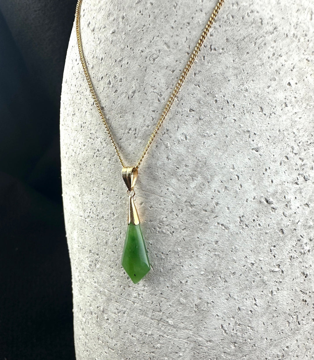 Gold chain necklace featuring a green drop pendant with a gold bail