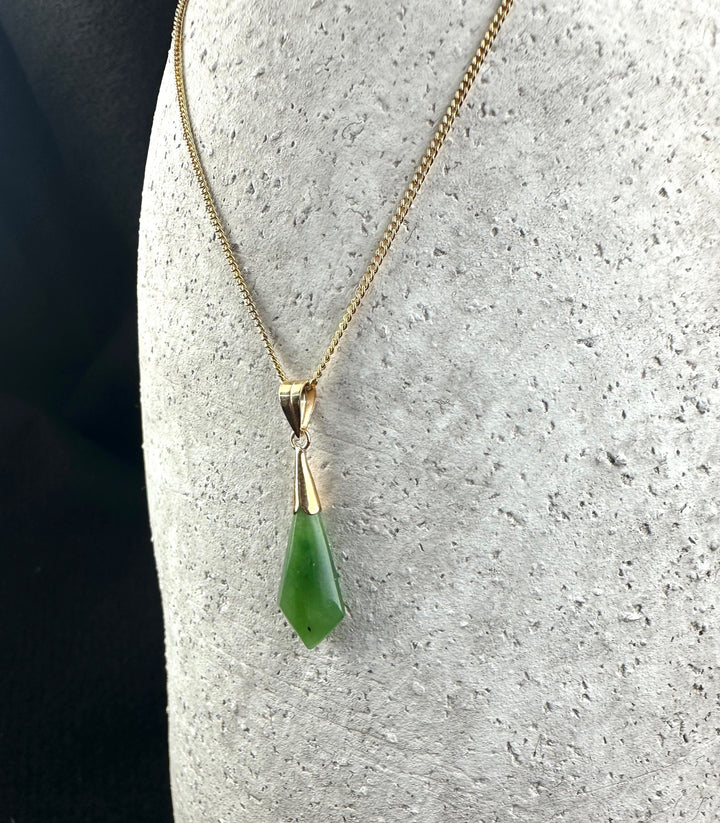 Gold chain necklace featuring a green drop pendant with a gold bail