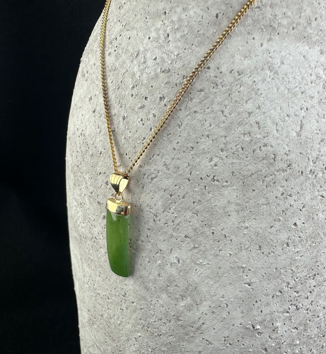 Front view of green jade rectangle drop pendant on a gold chain
