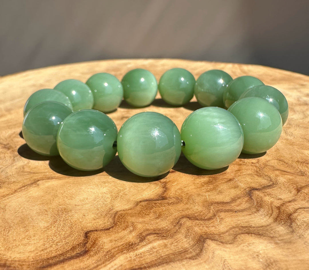 AA Green jade beads on wooden base