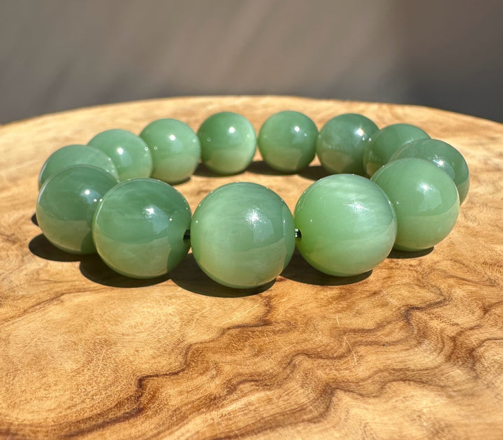 AA Green jade beads on wooden base