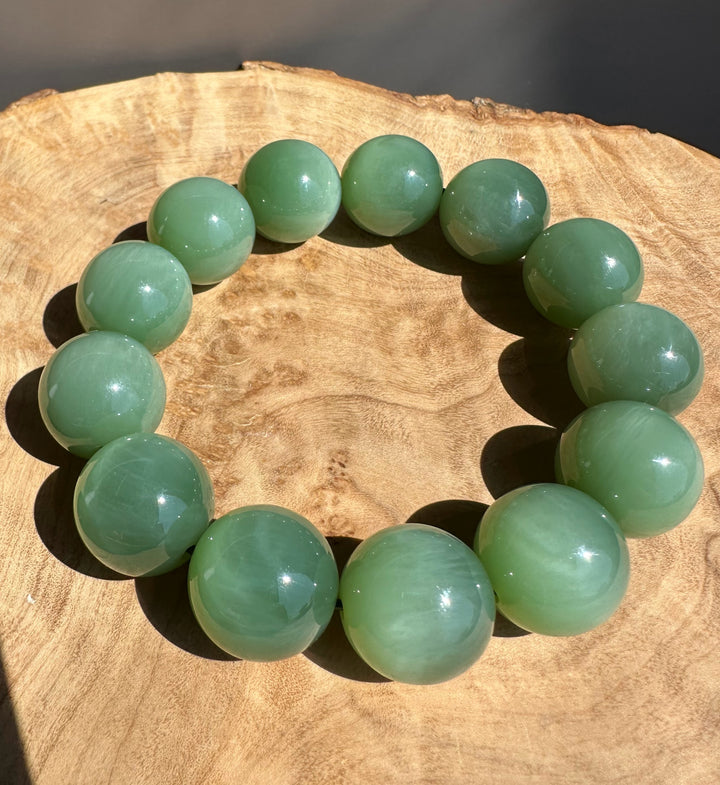 green jade beads on wooden base