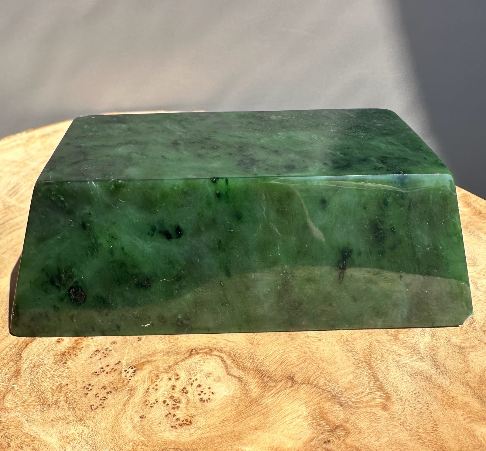 green jade ingot on wooden base