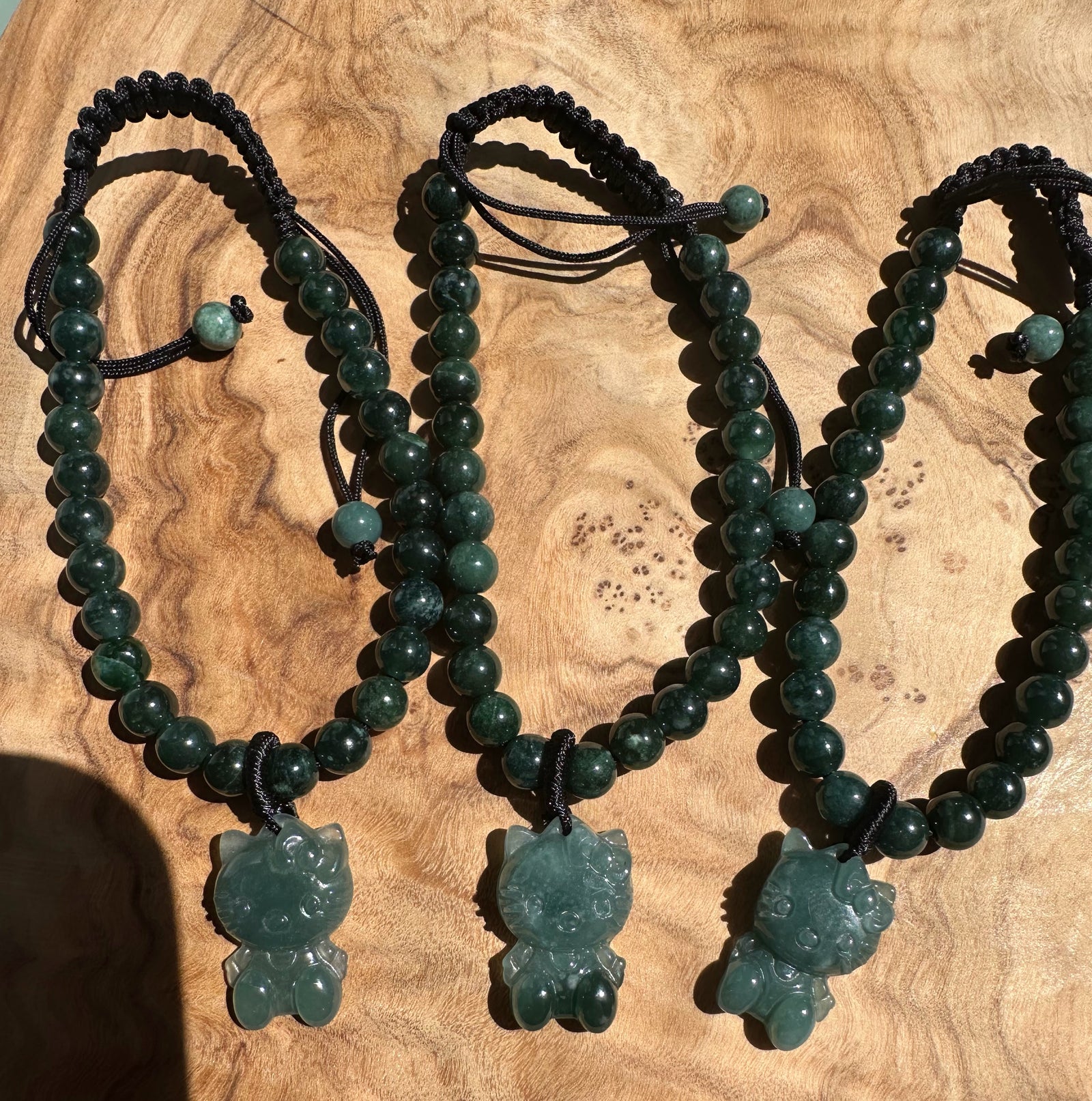 Three Guatemalan jadeite bead kitty bracelets with adjustable cords and cat pendants