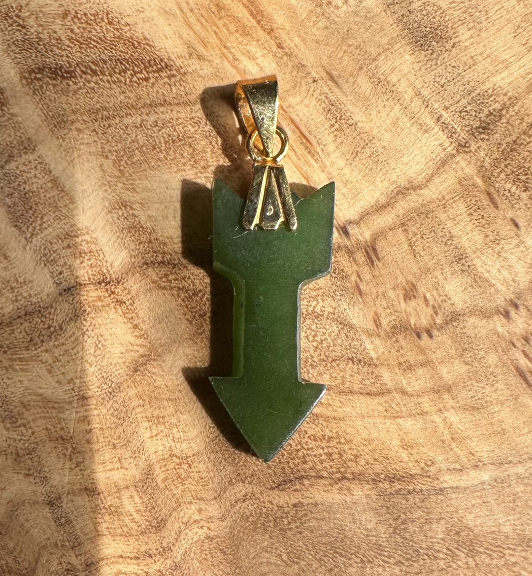 green jade arrow on wooden base