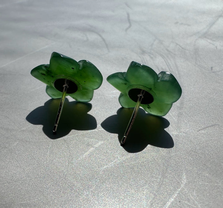 backlit green jade flower earrings on grey background