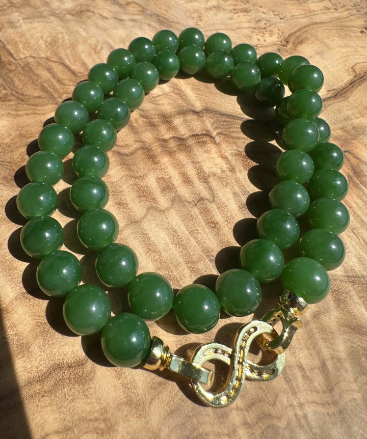 Green 10mm AA Siberian unstrung beads arranged on a wooden surface