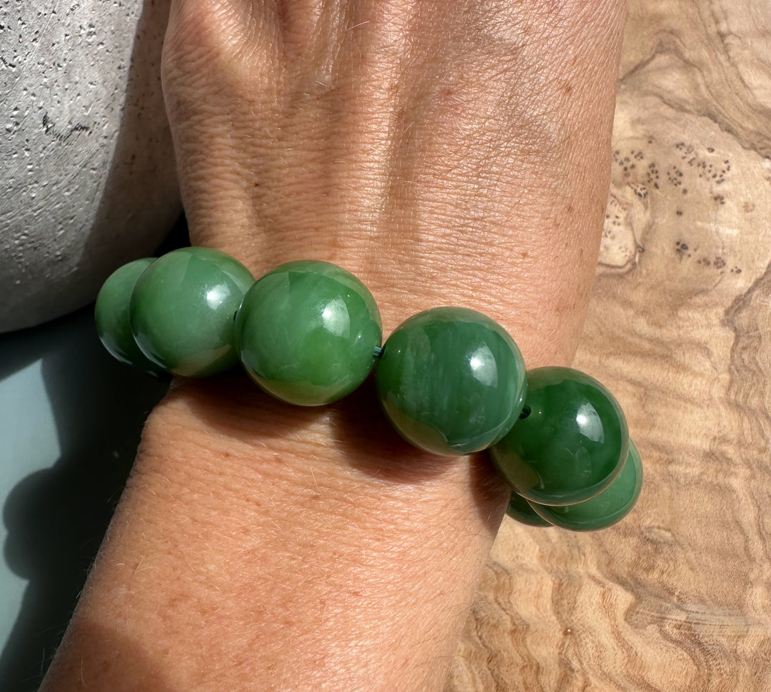 Wrist wearing an 18mm AA Siberian green bead bracelet.