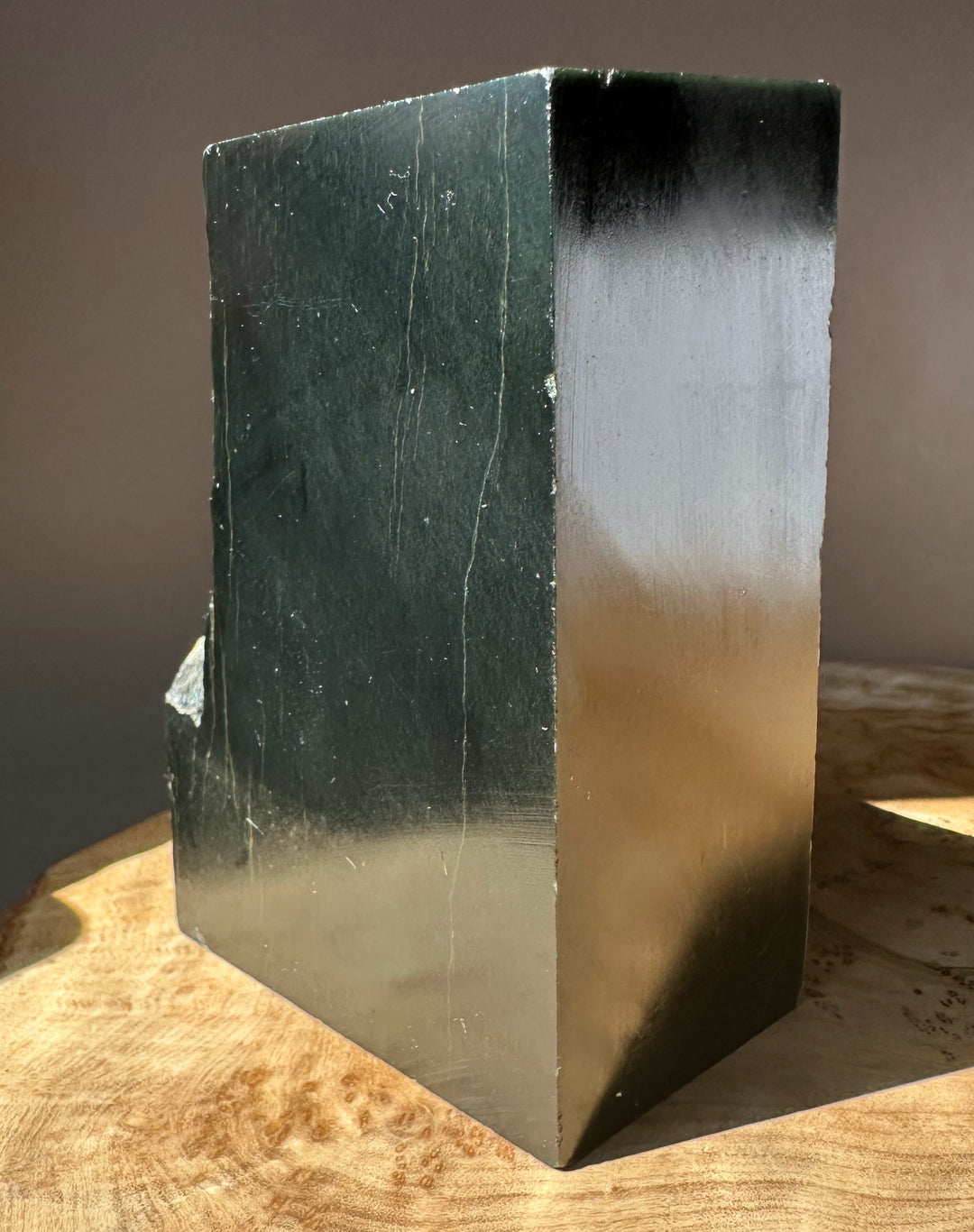 Wyoming slate block shown from the side with a dark left face and a lighter right face on wood