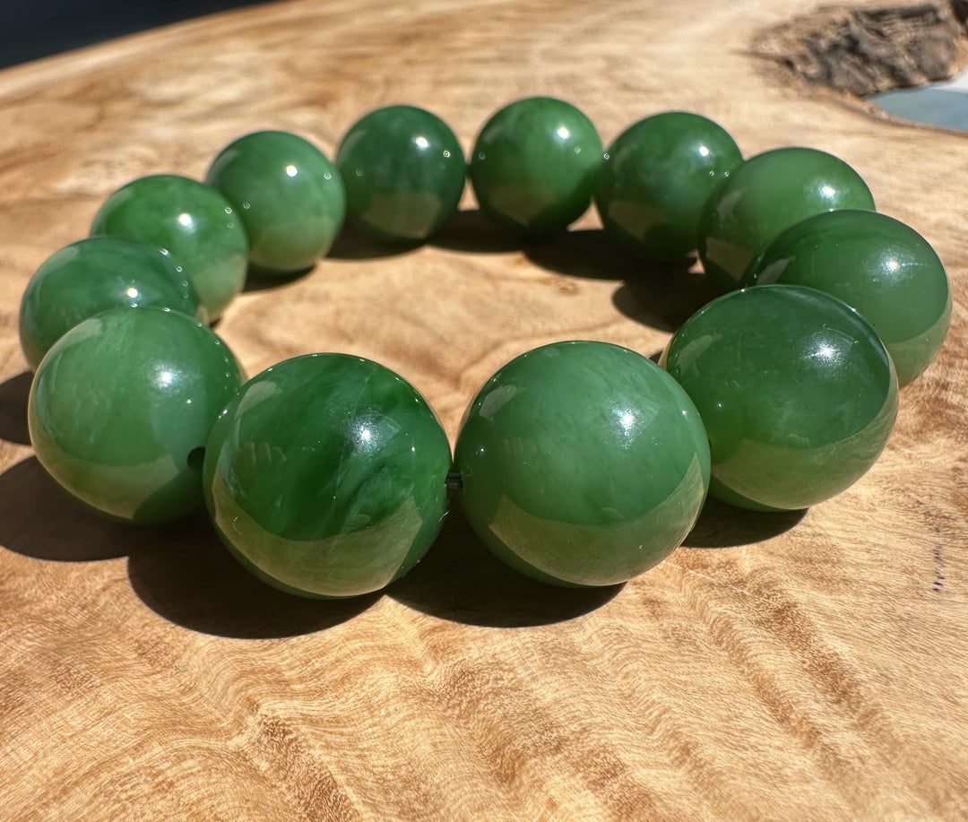 Diagonal shot of the green 18mm AA Siberian Bead Bracelet on a wooden background