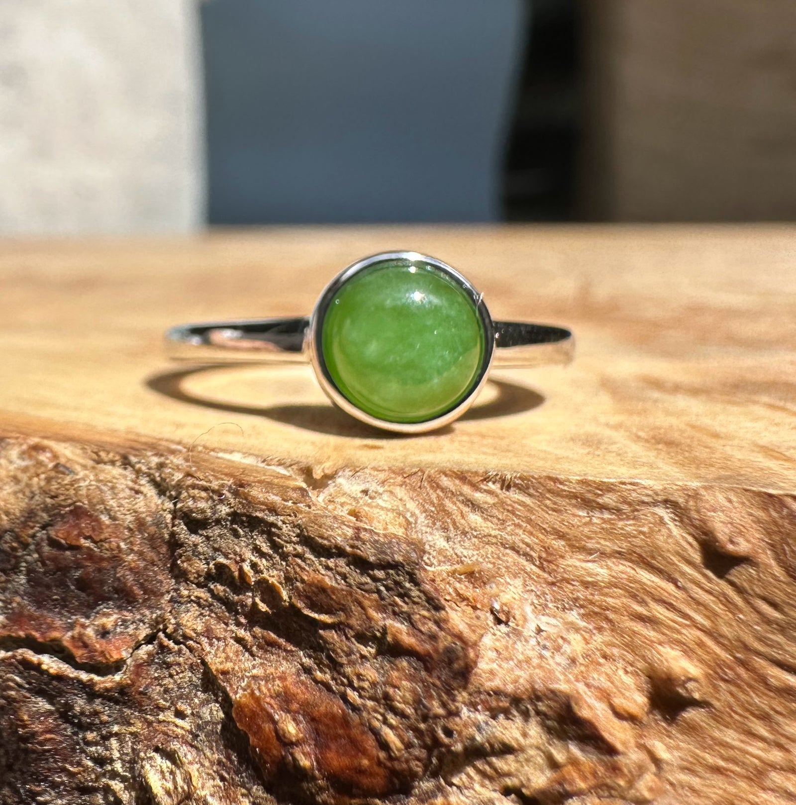 Silver ring with a round green jade cabochon set in a bezel.
