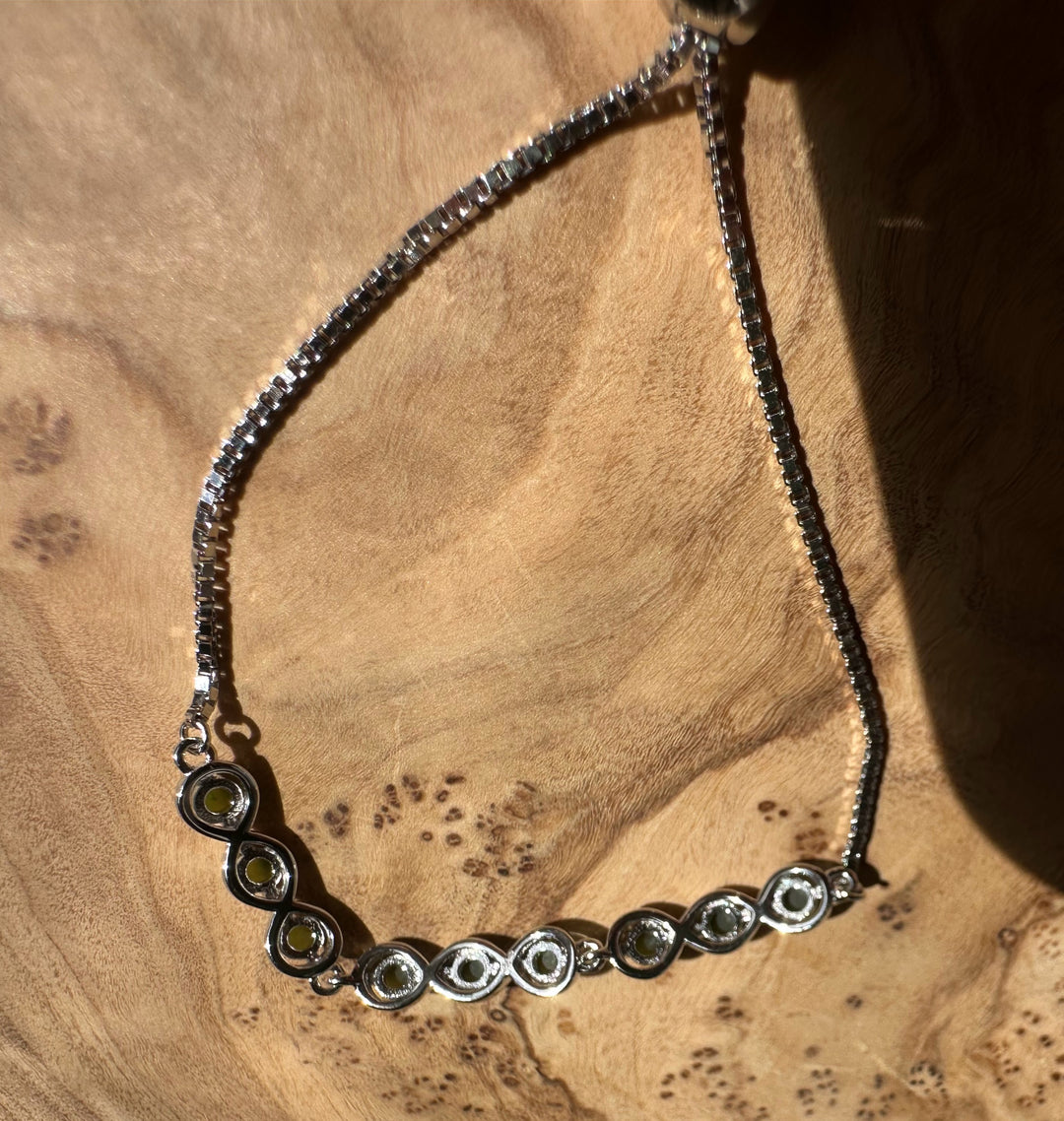 Sterling silver bracelet with circular linked settings each holding a green Canadian jade cabochon