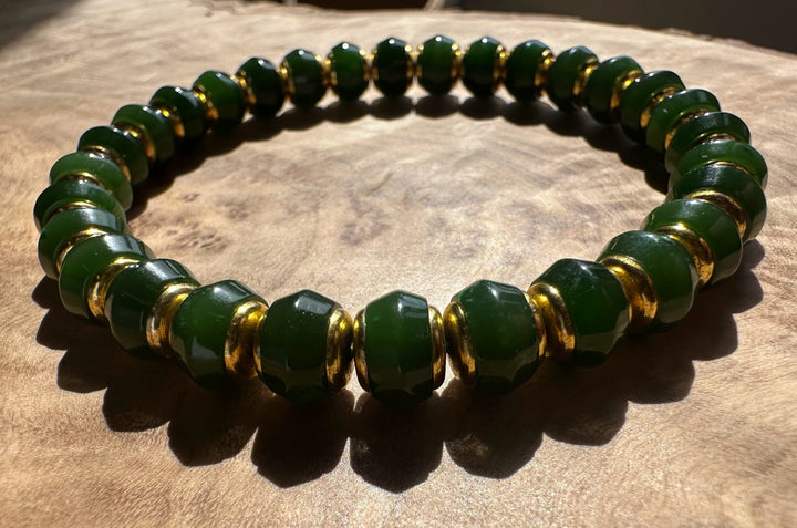 Dark green Canadian jade bead bracelet with 8mm beads and gold spacers worn on the wrist.