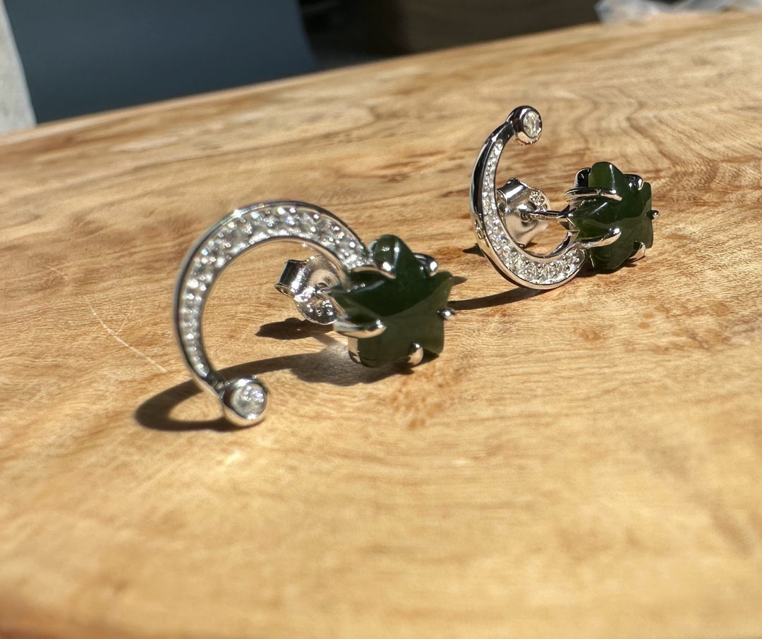 Silver Star and Moon Studs crescent with crystal pave and green star charm on a wooden surface