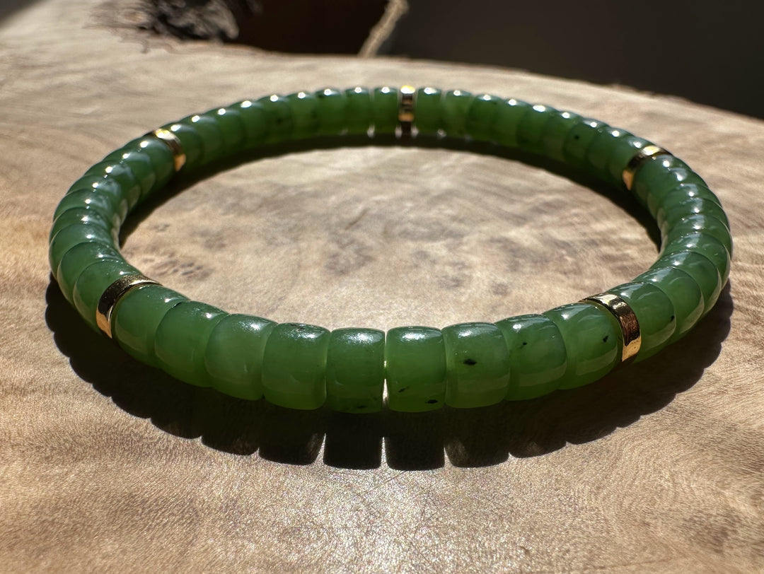 Side view of jade bead bracelet on wrist in sunlight.