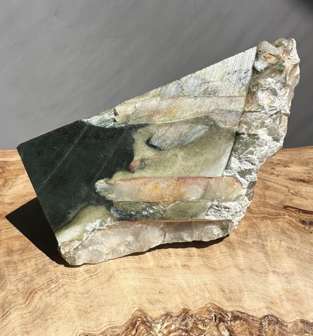 jade specimen on a wooden surface with a neutral background