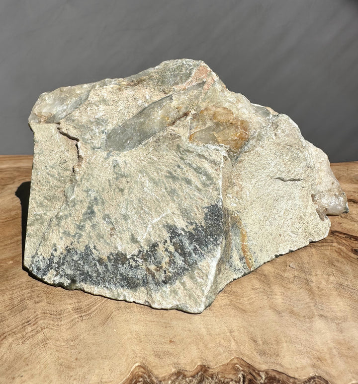 jade stone on a wooden surface with a dark background