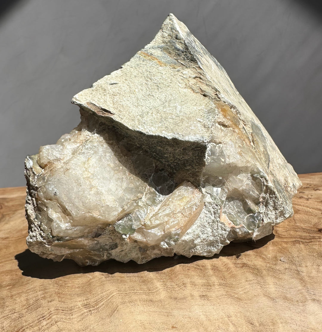 Raw crystal rock on a wooden surface with a dark background