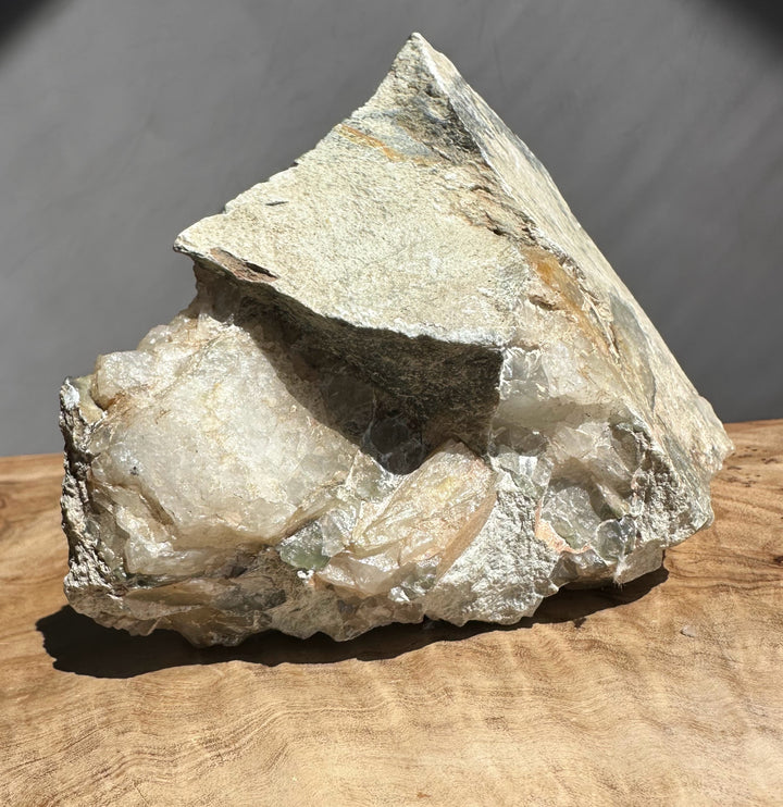 Raw crystal rock on a wooden surface with a dark background