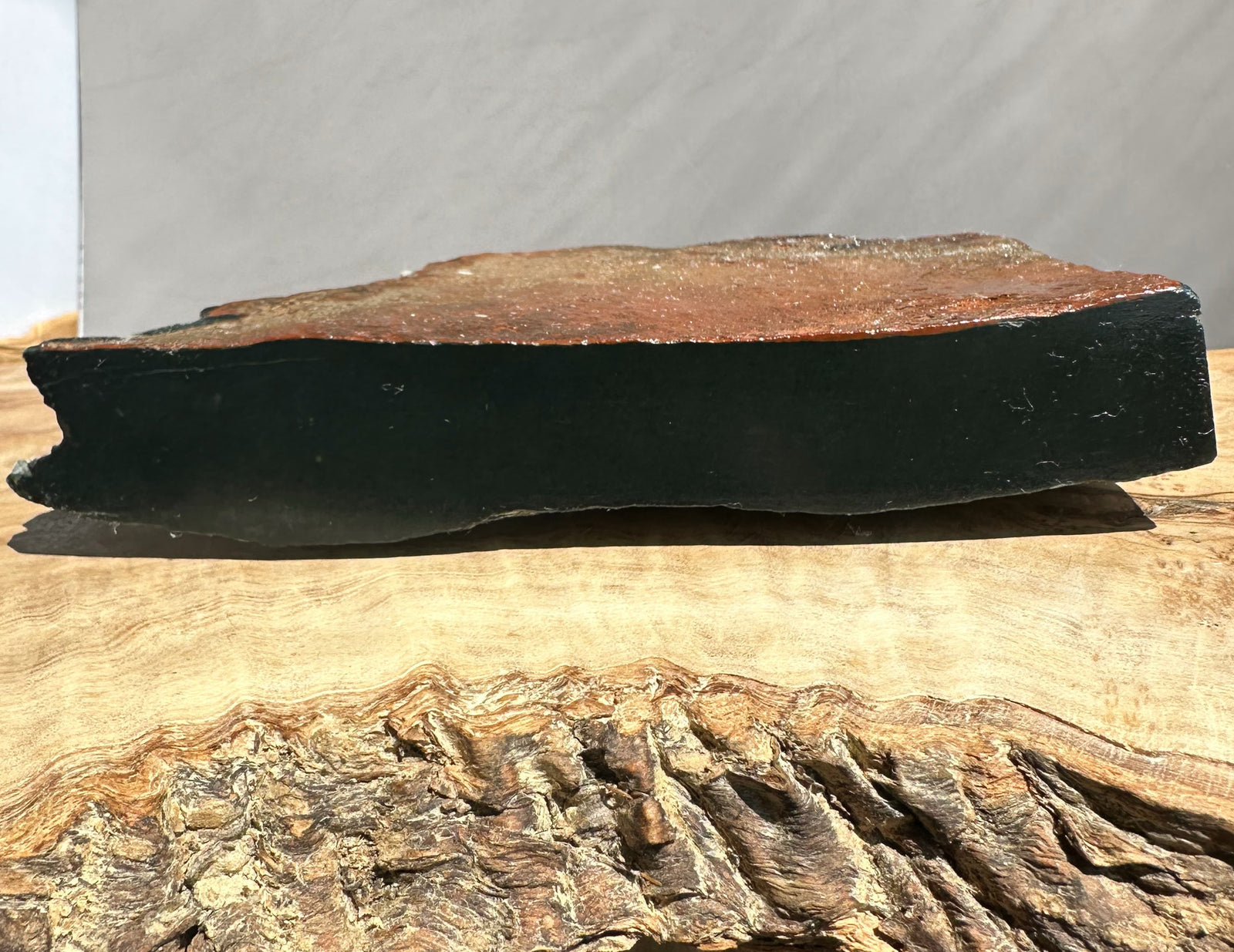 Dark jade on a wooden surface with a neutral background
