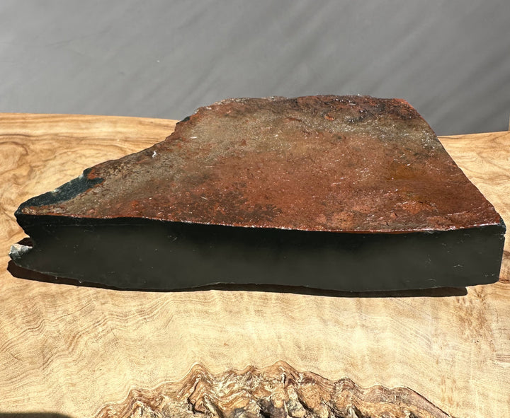 Wyoming jade black with red rind on a wooden surface with a gray background