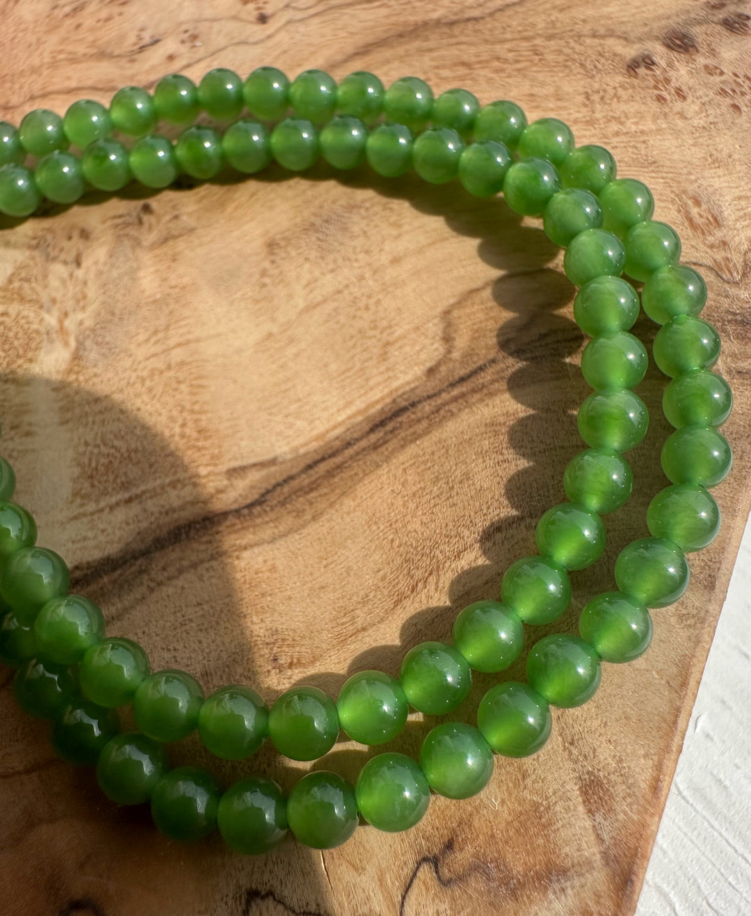 Green beaded bracelet on a wooden surface