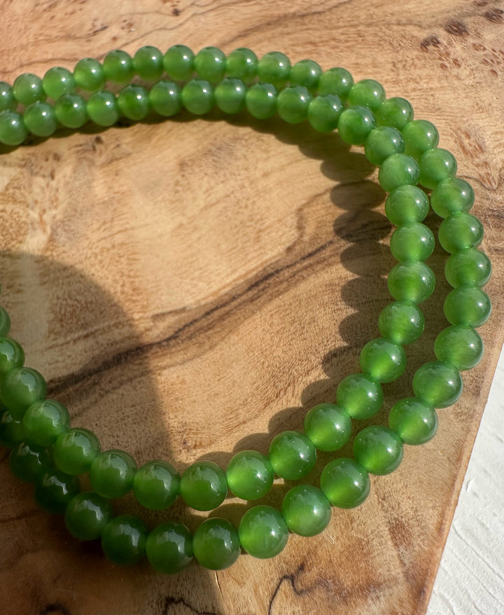 Green beaded bracelet on a wooden surface