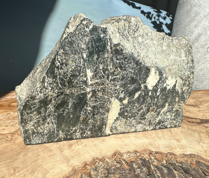 Cassiar Jade rough chunk showing dark green core with light veins and an irregular jagged top.